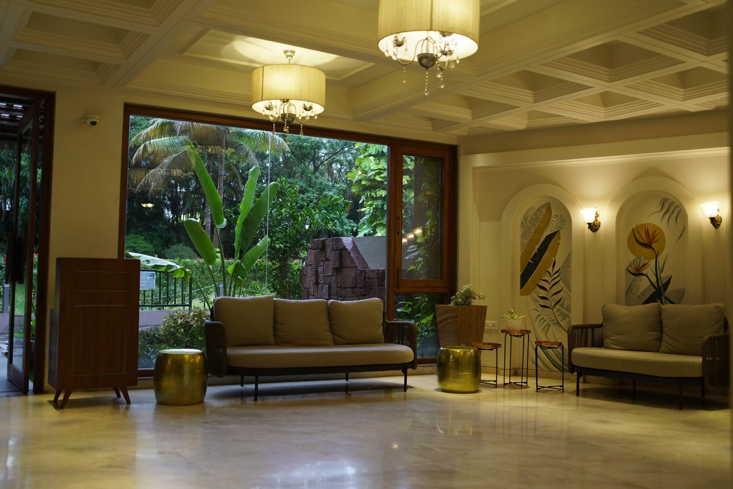 Palm-lined lawns and lit garden facade at The Pavillion Hotel at dusk